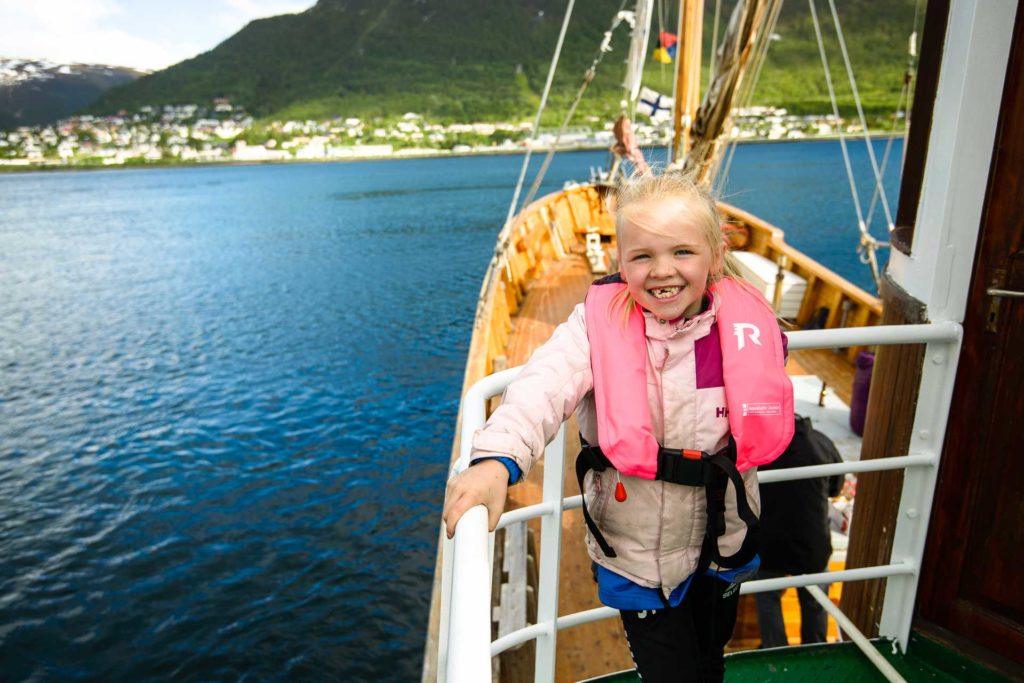 young girl in pink life west smiling to the camera