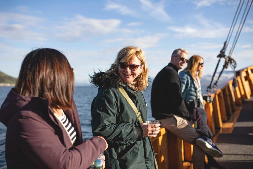 four people sitting on gunwale