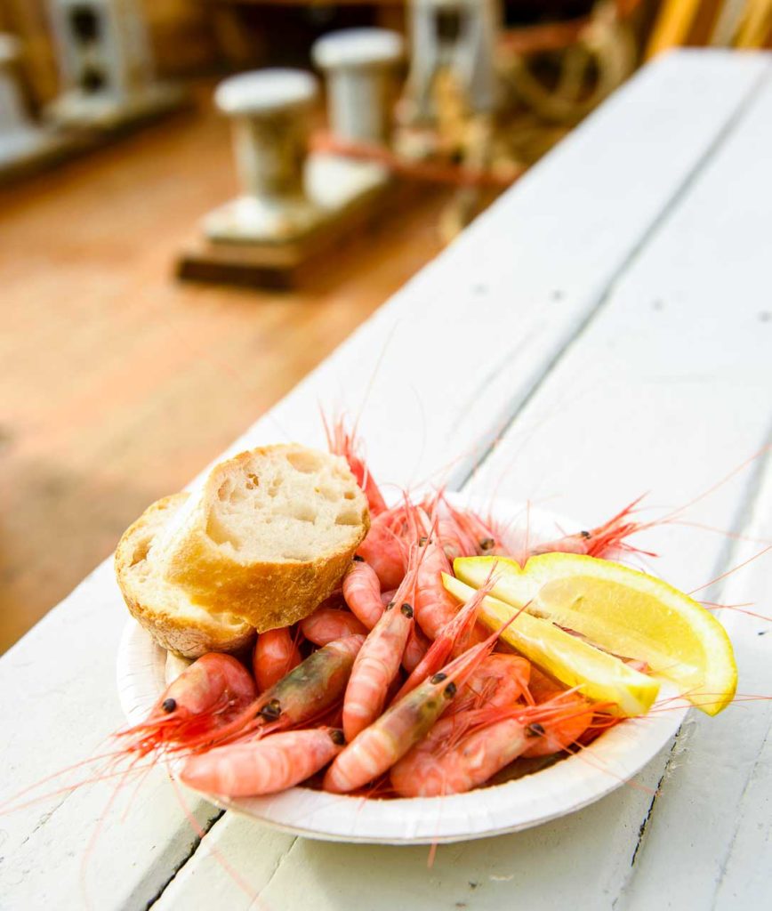 bowl of shrimps, white bread and lemon