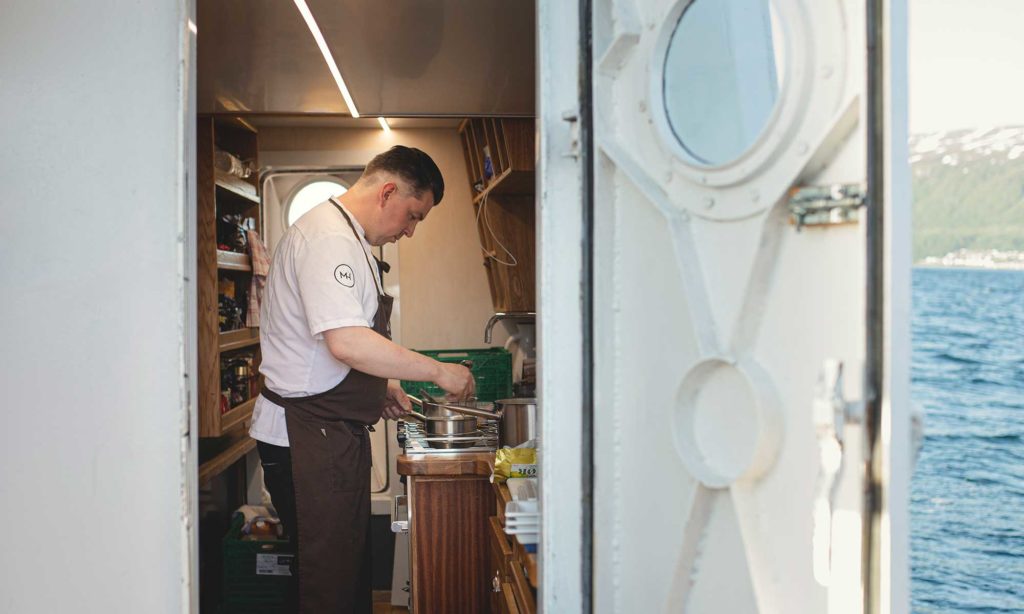 chef preparing food in galley